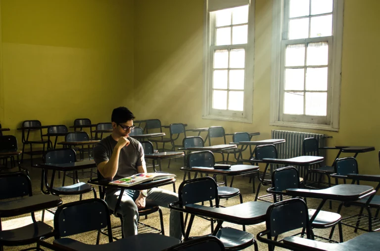 Étudiant seul sur un campus universitaire, illustrant le sentiment de ne pas se sentir à sa place